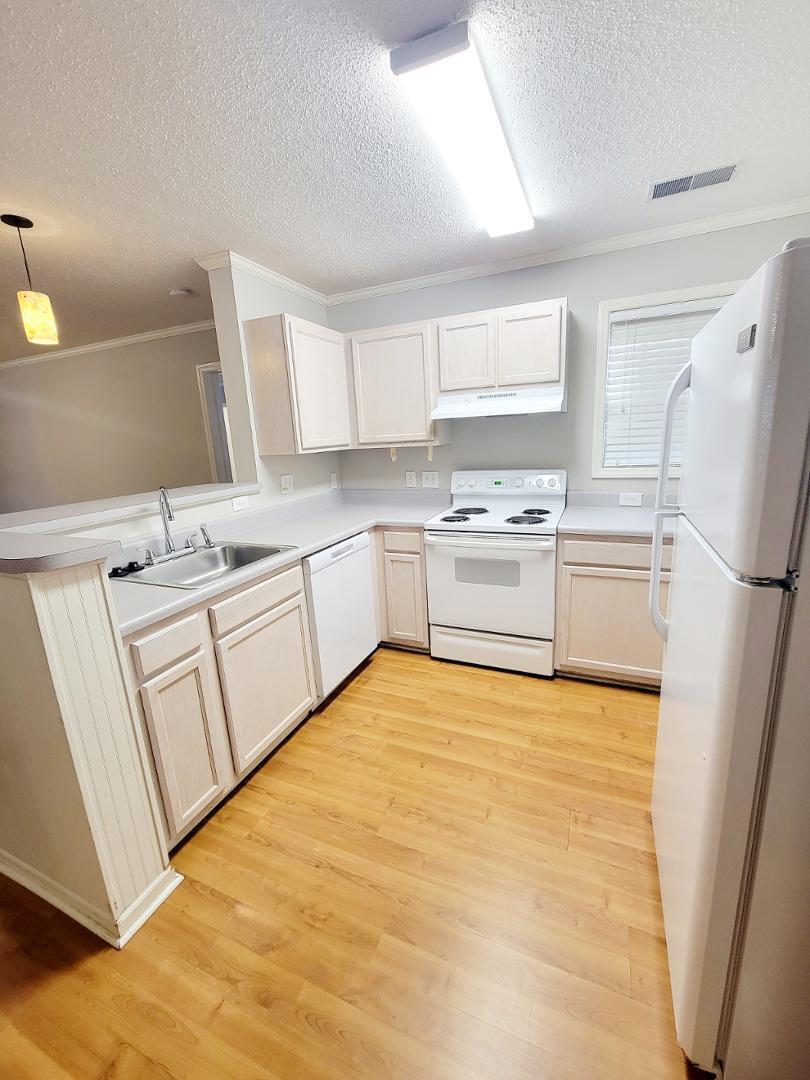 3770 Pardue Woods Place, Unit 103 Raleigh, NC 27603 - Photo 3 of 42 a kitchen with white cabinets and white appliances