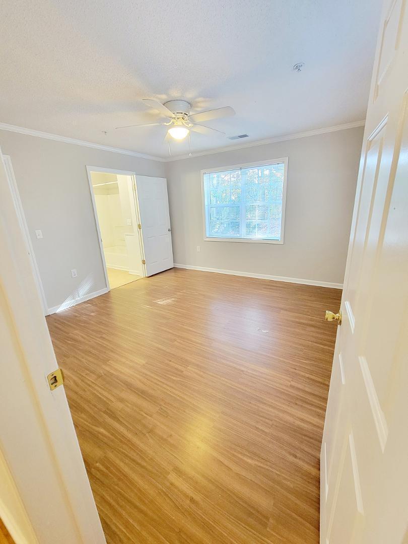 3770 Pardue Woods Place, Unit 103 Raleigh, NC 27603 - Photo 31 of 42 a view of an empty room with wooden floor and a window