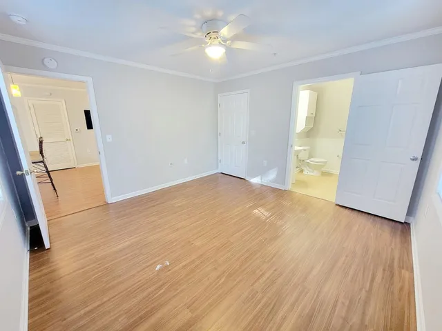 a view of an empty room with window and wooden floor