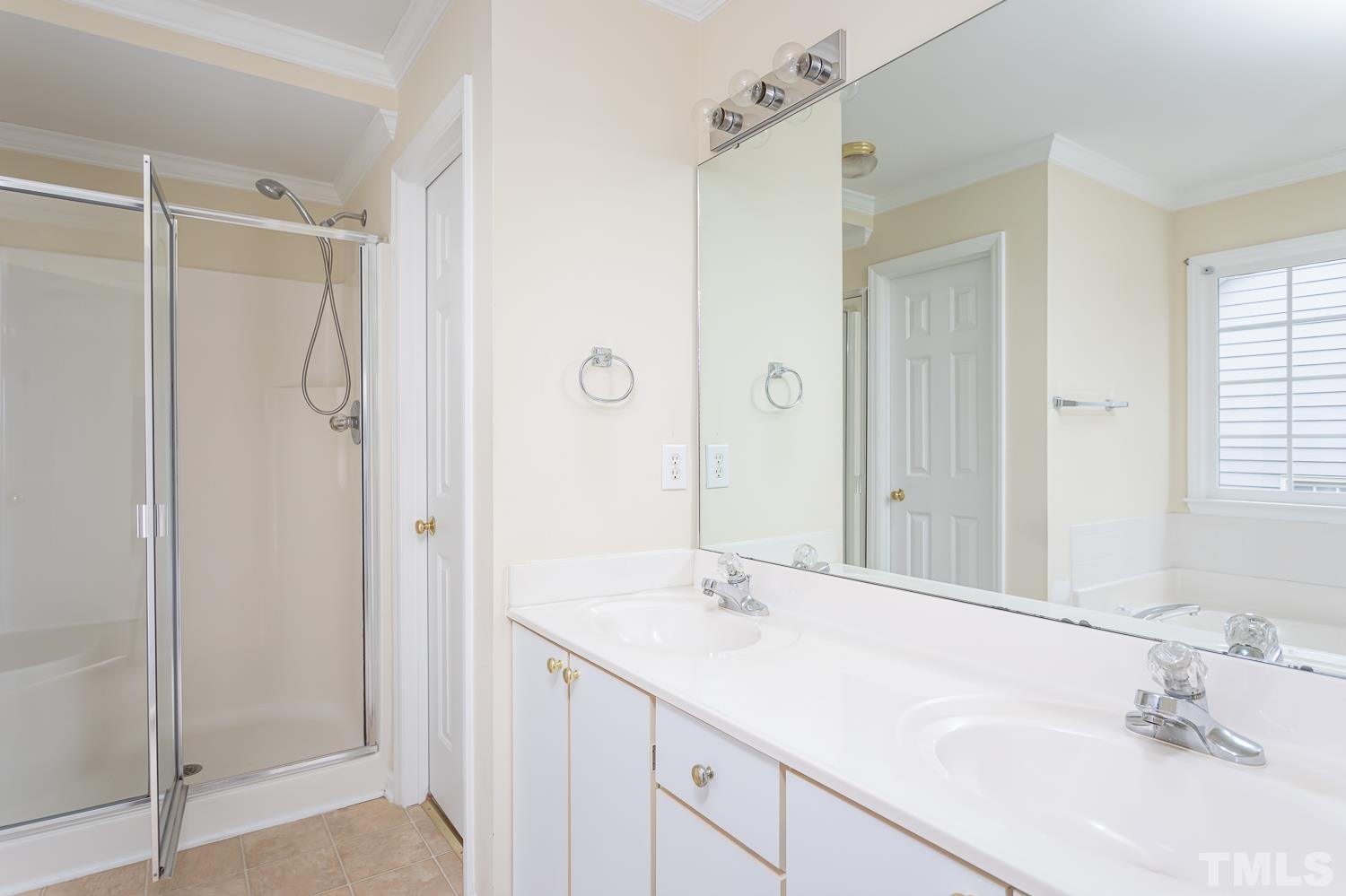 8669 Harps Mill Road Raleigh, NC 27615 - Photo 7 of 13 a bathroom with a shower sink and mirror