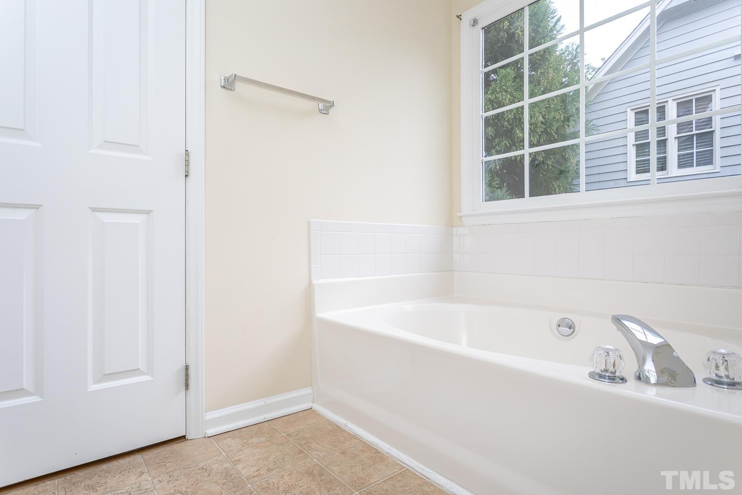 8669 Harps Mill Road Raleigh, NC 27615 - Photo 8 of 13 a bathroom with bathtub and window