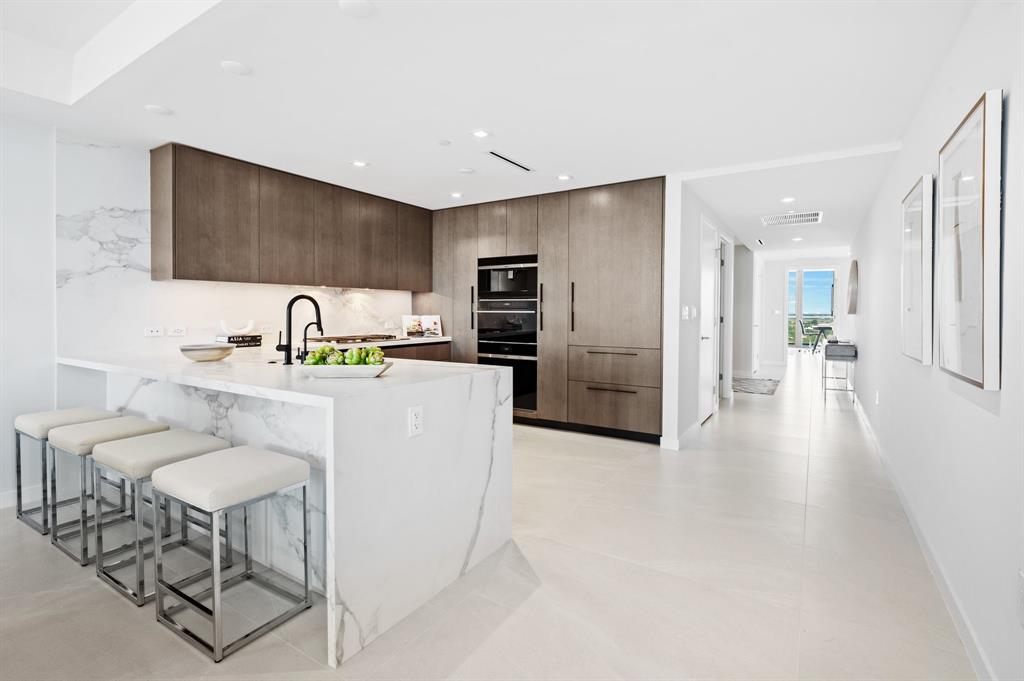 1116 North Ocean Boulevard, Unit 1606 Pompano Beach, FL 33062 - Photo 12 of 83 a kitchen with stainless steel appliances kitchen island a refrigerator and a sink