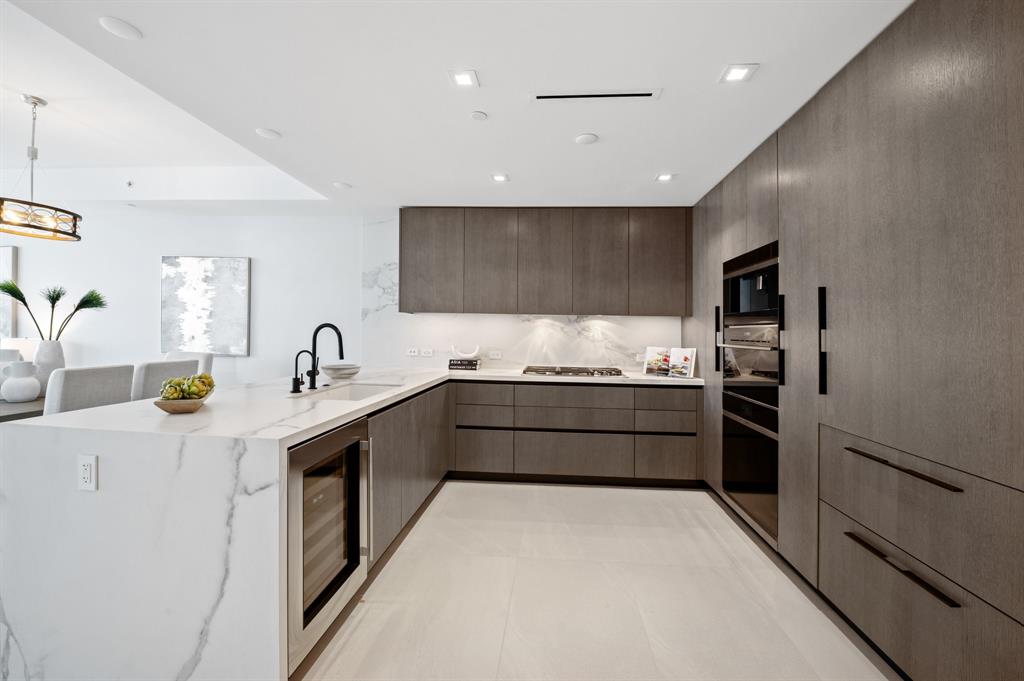 1116 North Ocean Boulevard, Unit 1606 Pompano Beach, FL 33062 - Photo 13 of 83 a large kitchen with stainless steel appliances kitchen island granite countertop a refrigerator and a sink