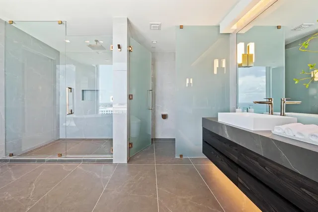 a bathroom with a double vanity sink toilet mirror and shower