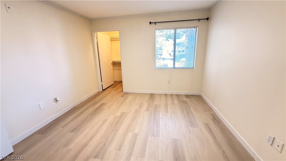 7885 West Flamingo Road, Unit 1131 Las Vegas, NV 89147 - Photo 31 of 36 A spacious bedroom featuring light wood flooring and a convenient walk-in closet.