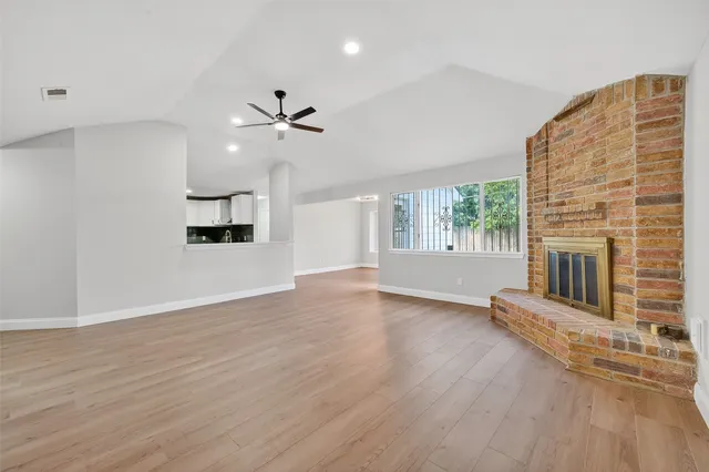 an empty room with windows and fireplace