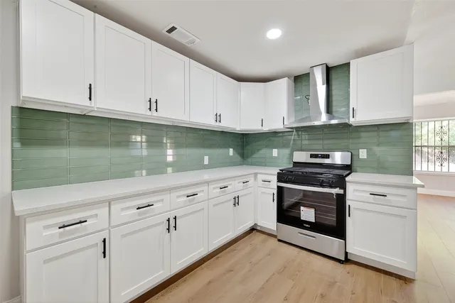 a kitchen with granite countertop white cabinets and white appliances