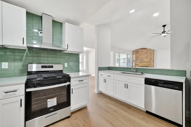 a kitchen with granite countertop white cabinets and stainless steel appliances