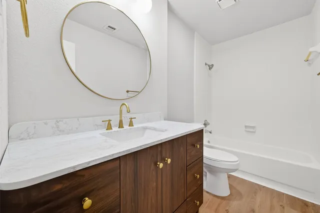 a bathroom with a sink a toilet and a mirror