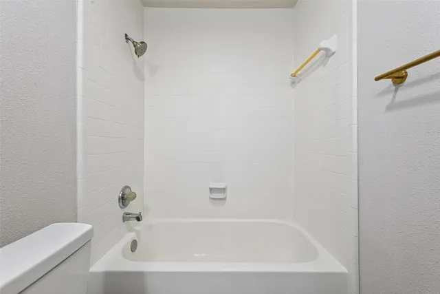 a white bath tub sitting next to a white sink and vanity