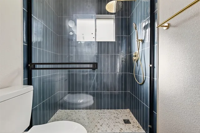 a bathroom with a toilet and a shower