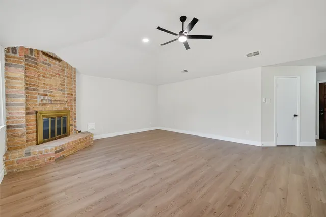 a view of a livingroom with wooden floor and a fireplace