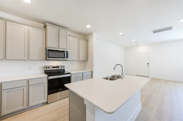 a kitchen with a sink a stove a microwave and cabinets