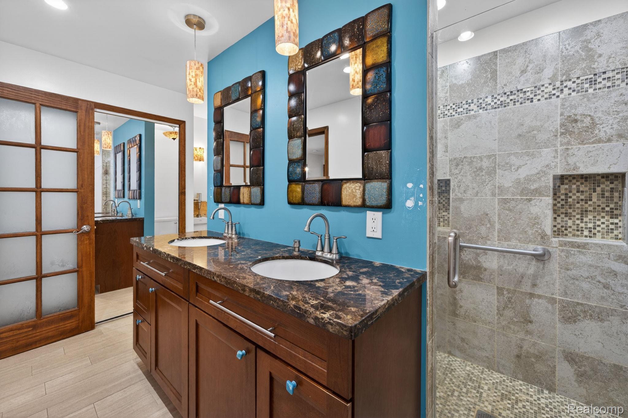 9353 Hill Road Swartz Creek, MI 48473 - Photo 44 of 98 Dual vanity featuring dark wood cabinetry, integrated sinks, and a stone-finish countertop