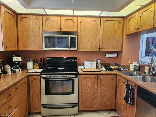 a kitchen with appliances a refrigerator and a sink