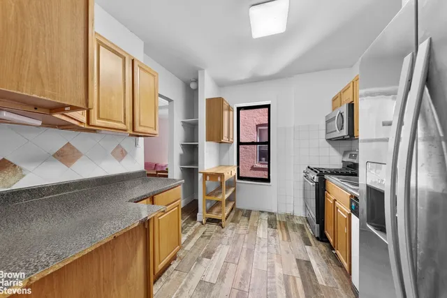 a kitchen with stainless steel appliances granite countertop a refrigerator stove and oven