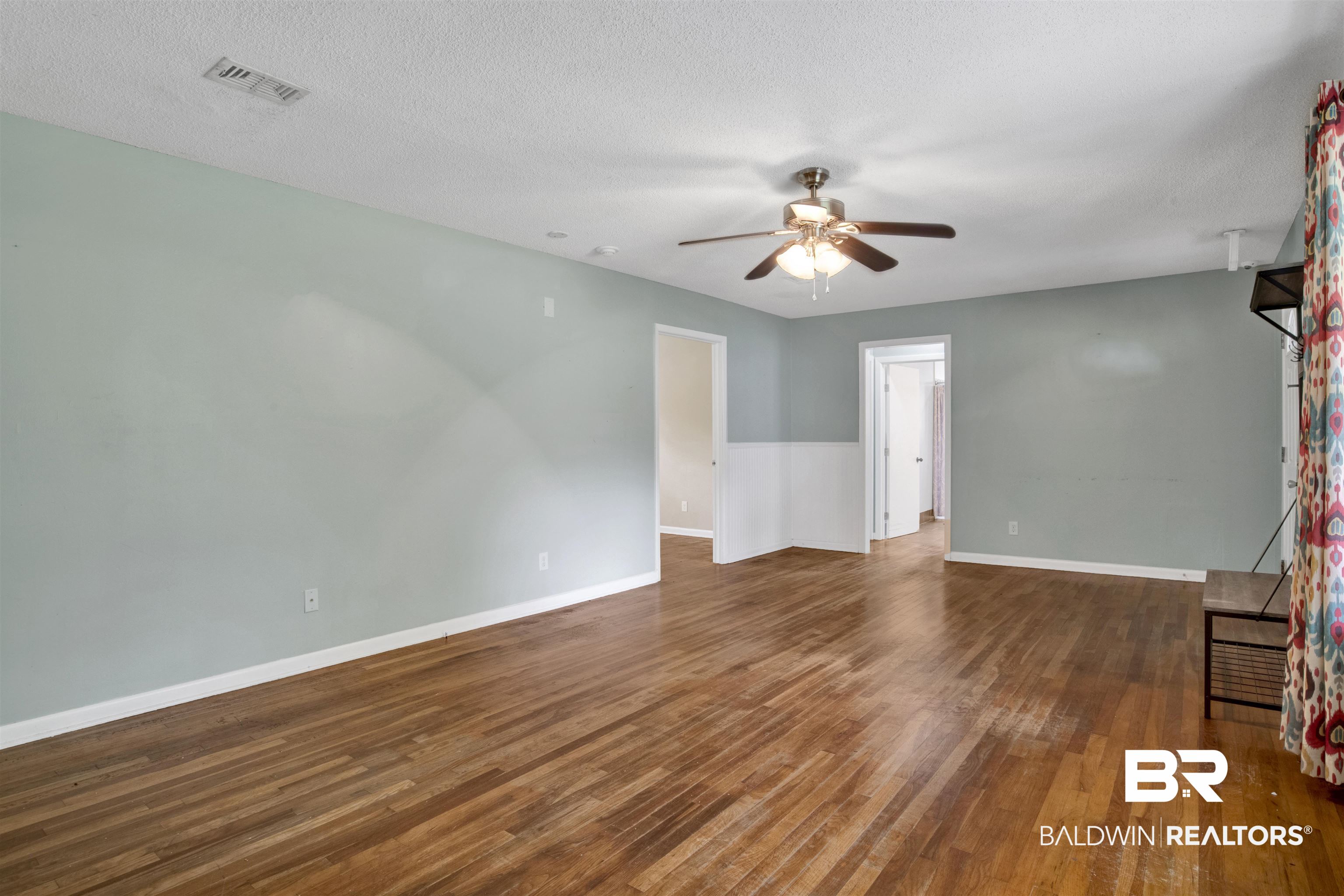 17714 Horseneck Road Bay Minette, AL 36507 - Photo 8 of 36 Spacious room featuring wood-finish flooring, a ceiling fan with integrated lighting, and a white baseboard trim