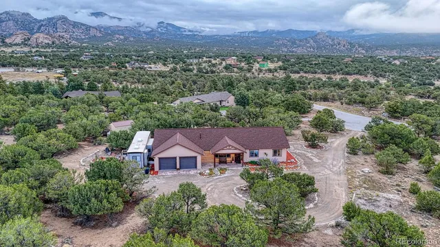 an aerial view of a house with a mountain