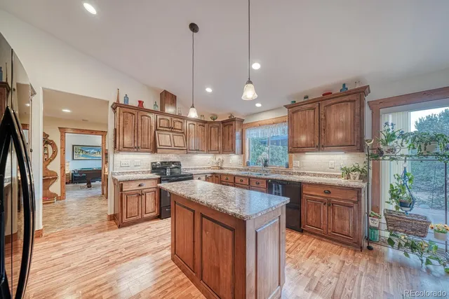 a kitchen with stainless steel appliances granite countertop a stove a sink dishwasher a refrigerator and a wooden cabinets