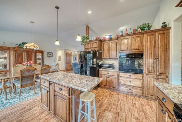 a kitchen with stainless steel appliances granite countertop a stove top oven a refrigerator and kitchen island