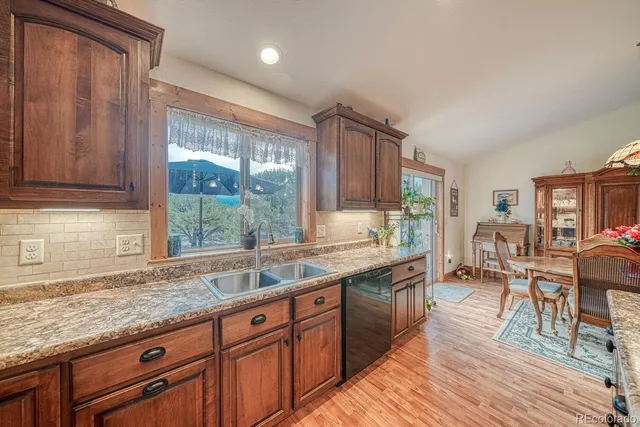 a kitchen with granite countertop a sink and wooden cabinets