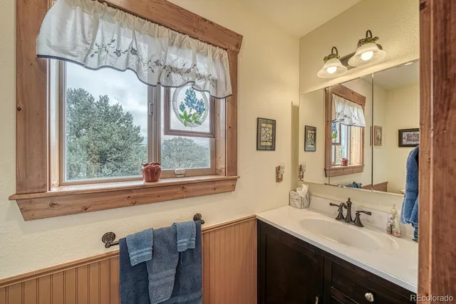 a bathroom with a double vanity sink mirror and a large window