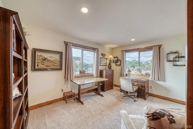 a view of a livingroom with workspace and a window