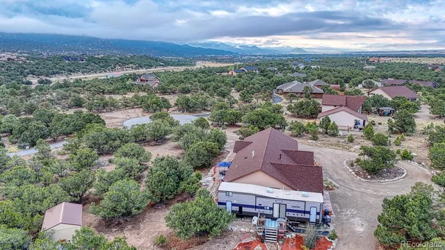 an aerial view of residential houses with outdoor space and trees