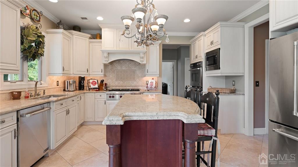 5 Daisy Court Skillman, NJ 08558 - Photo 22 of 50 a large kitchen with stainless steel appliances a table chairs sink and cabinets