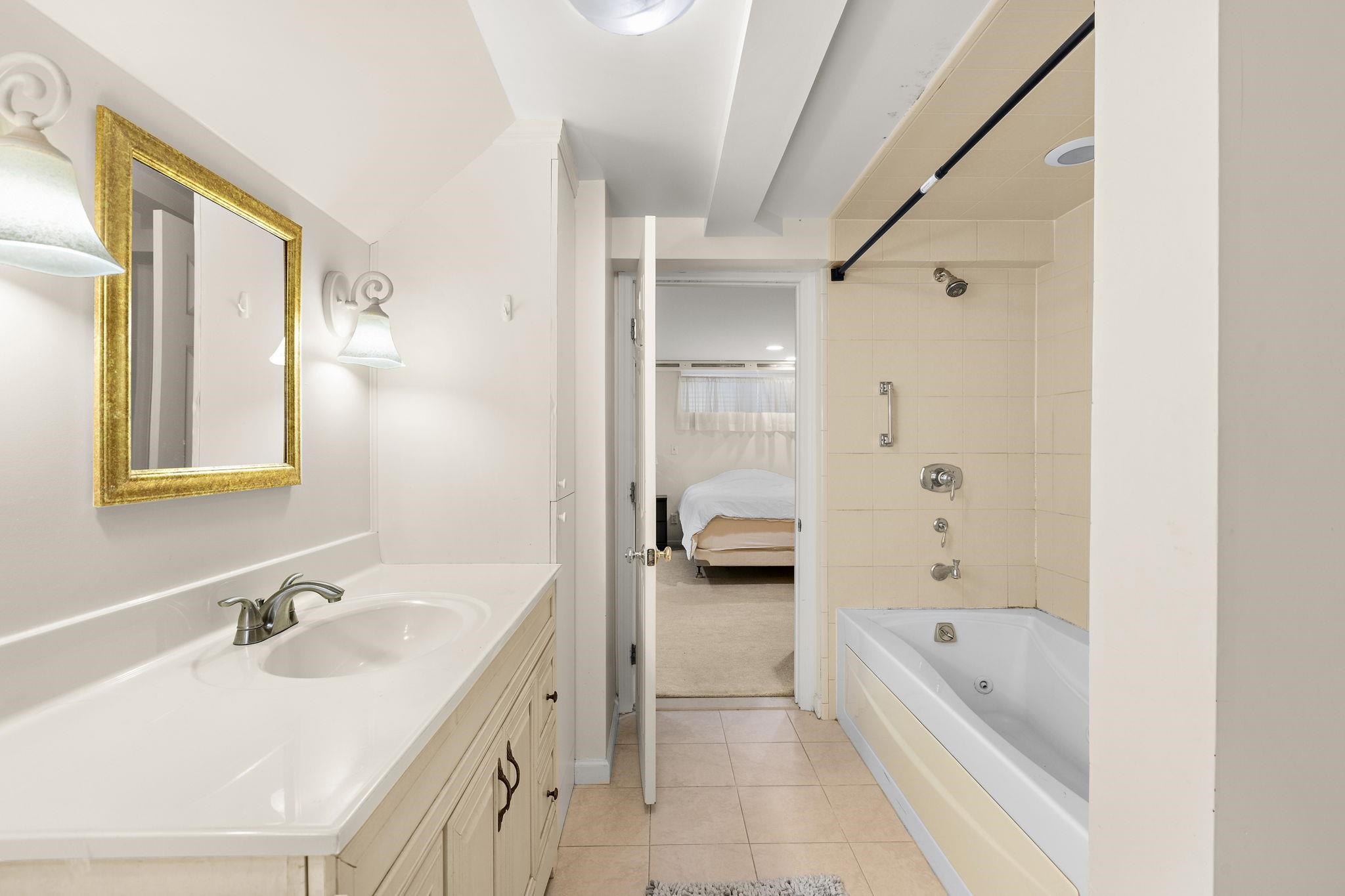 97 Riverview Avenue Cliffside Park, NJ 07010 - Photo 12 of 26 a bathroom with a tub double vanity sink and mirror