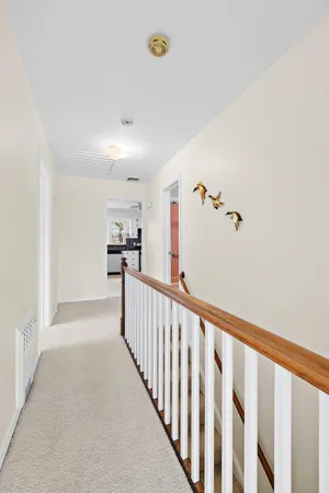 a view of a hallway with wooden floor and staircase