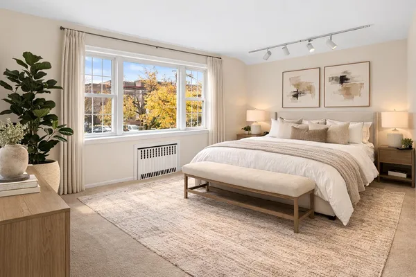 a spacious bedroom with a large bed and a potted plant