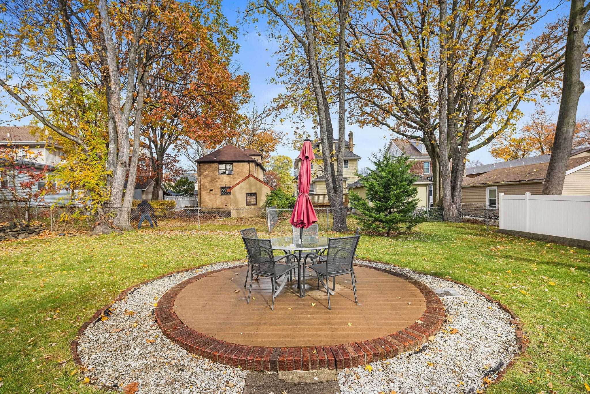 97 Riverview Avenue Cliffside Park, NJ 07010 - Photo 20 of 26 a view of a backyard with table and chairs potted plants and large tree