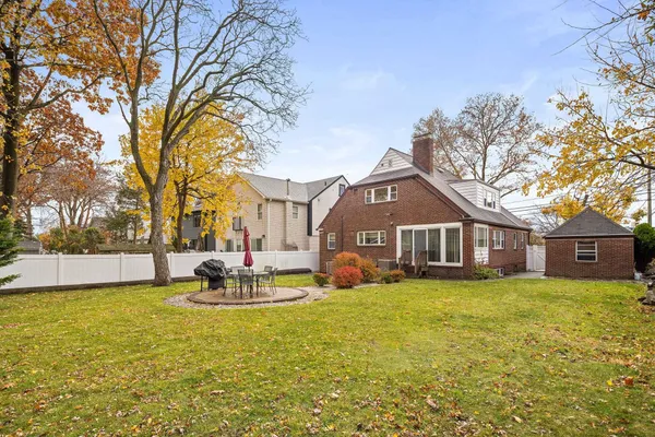 a view of a house with a big yard and large trees