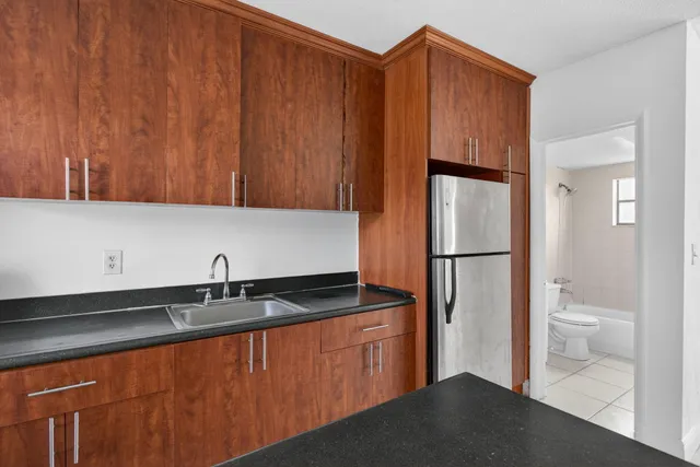 a kitchen with a sink a refrigerator and cabinets