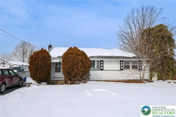 a view of a house with a yard covered in snow