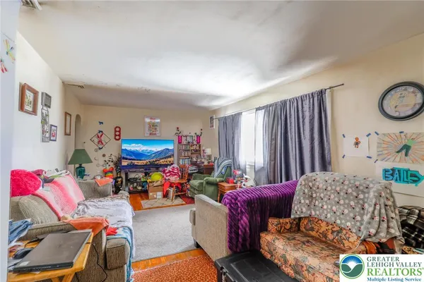 a living room with furniture and a baby crib