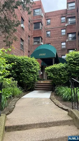 a front view of a building with a garden and plants