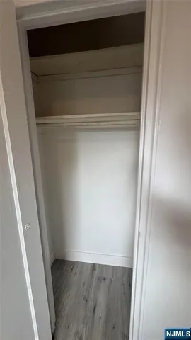 a view of walk in closet with wooden floor