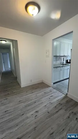 an empty room with wooden floor and cabinet