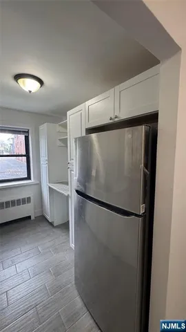 a view of a refrigerator in kitchen and a window