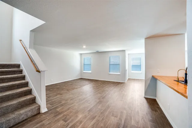 a view of a room with wooden floors and stairs