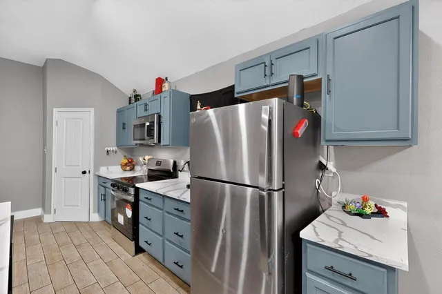a kitchen with stainless steel appliances a refrigerator sink and cabinets