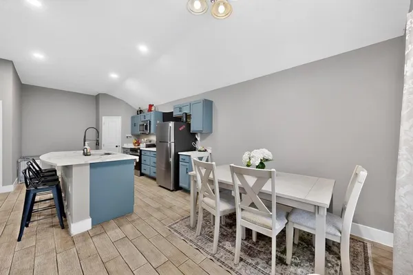 a kitchen with a dining table chairs and entryway