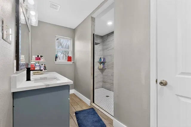 a bathroom with a sink mirror and a shower