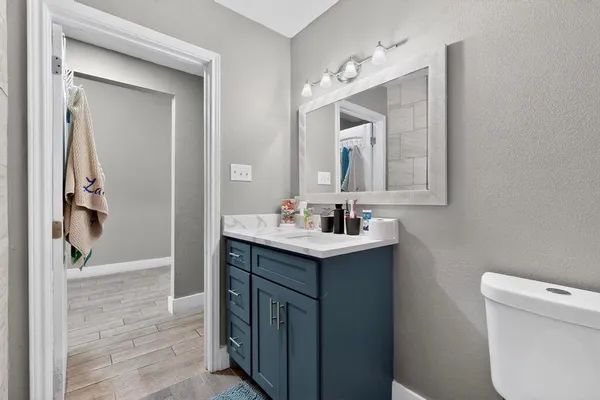 a bathroom with a sink a toilet and mirror