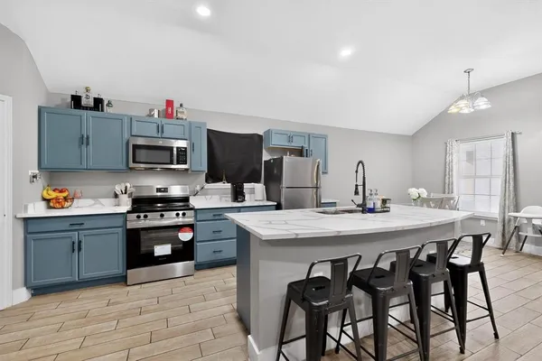 a kitchen with stainless steel appliances kitchen island granite countertop a sink and cabinets