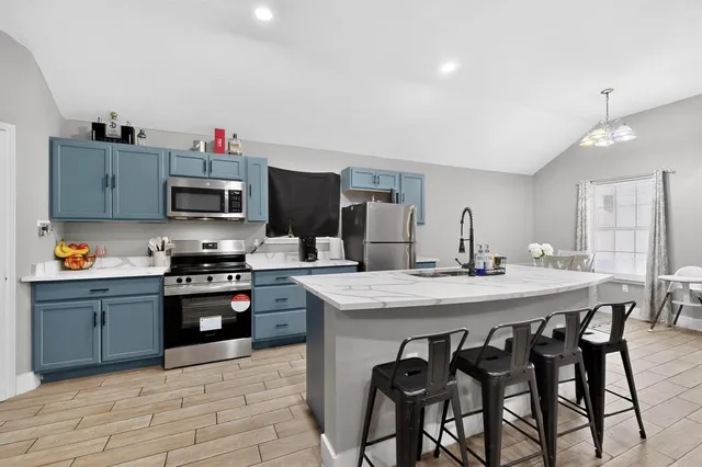 a kitchen with stainless steel appliances kitchen island granite countertop a sink and cabinets