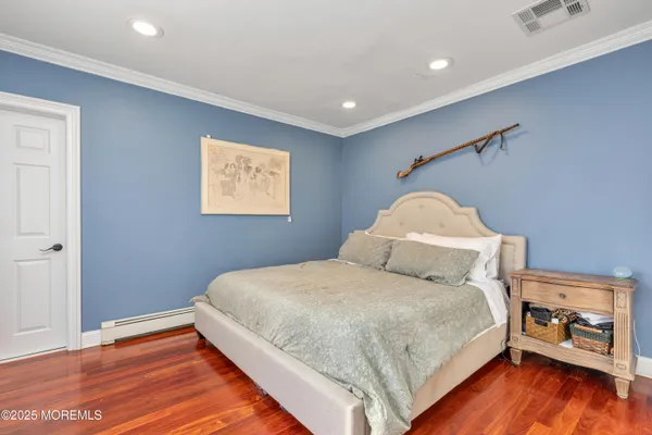 a bedroom with a bed and a wooden floor