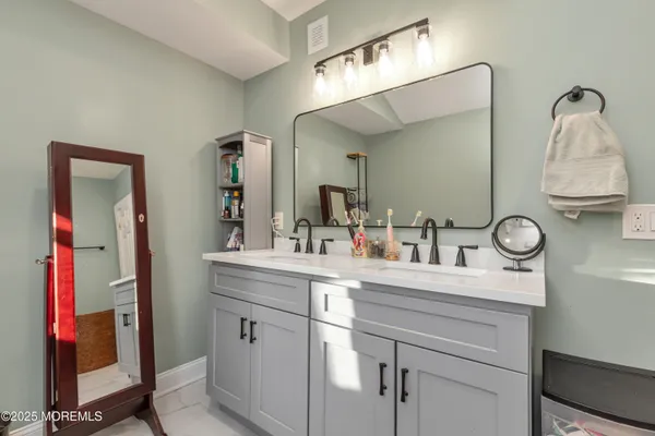 a bathroom with a sink vanity and mirror